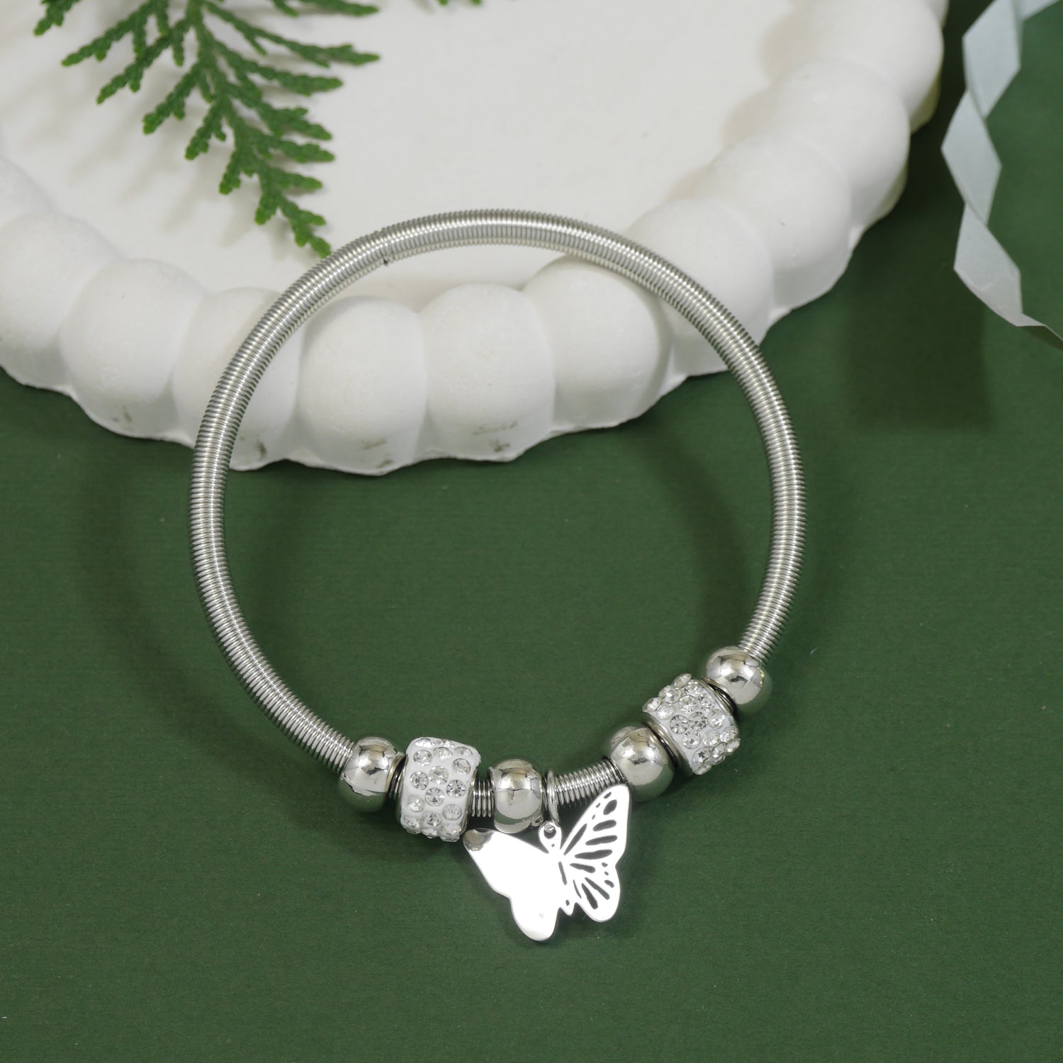 Silver charm bracelet with butterfly pendant and shimmering rhinestone beads