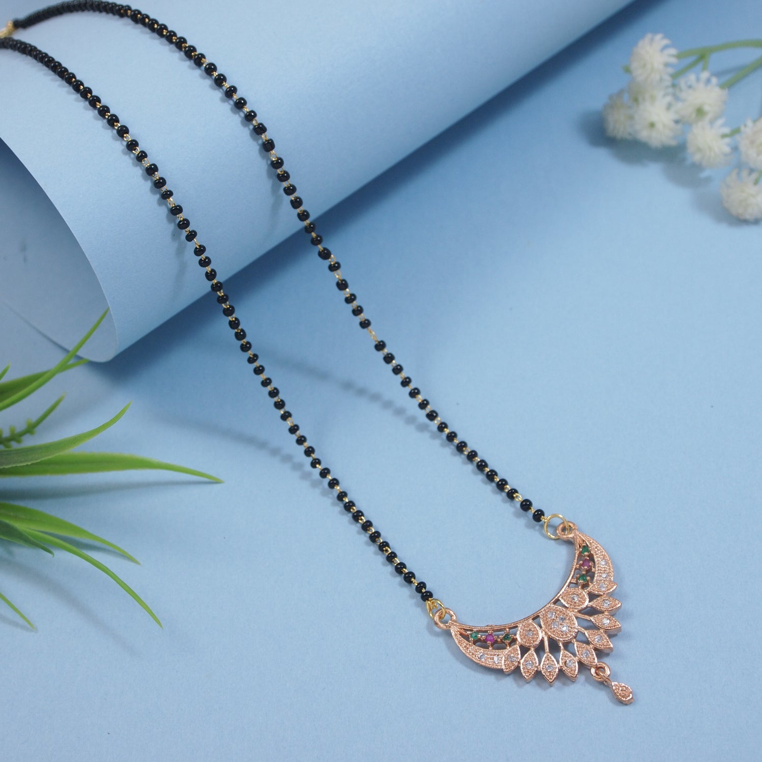 Ethnic gold-tone mangalsutra with black beads design for brides and festive wear.