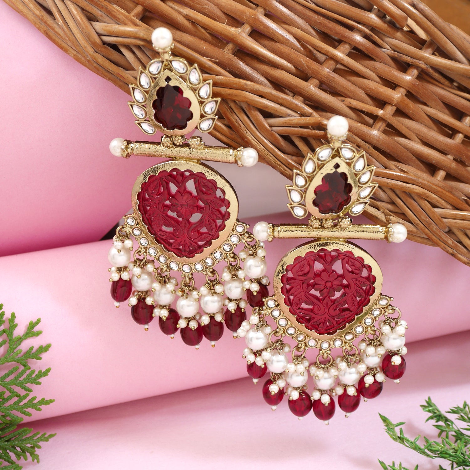 Antique gold-plated maroon kundan jhumka earrings with pearl drops and floral carving
