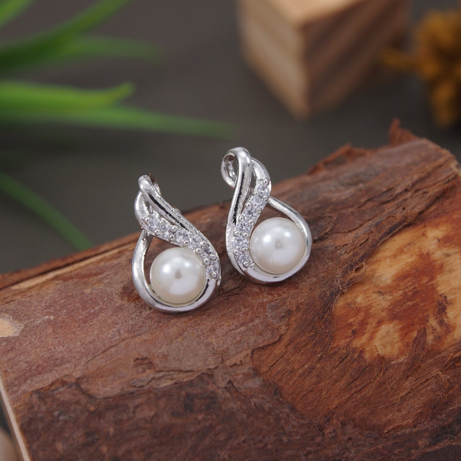 Silver stud earrings with flame-shaped crystal design and pearl