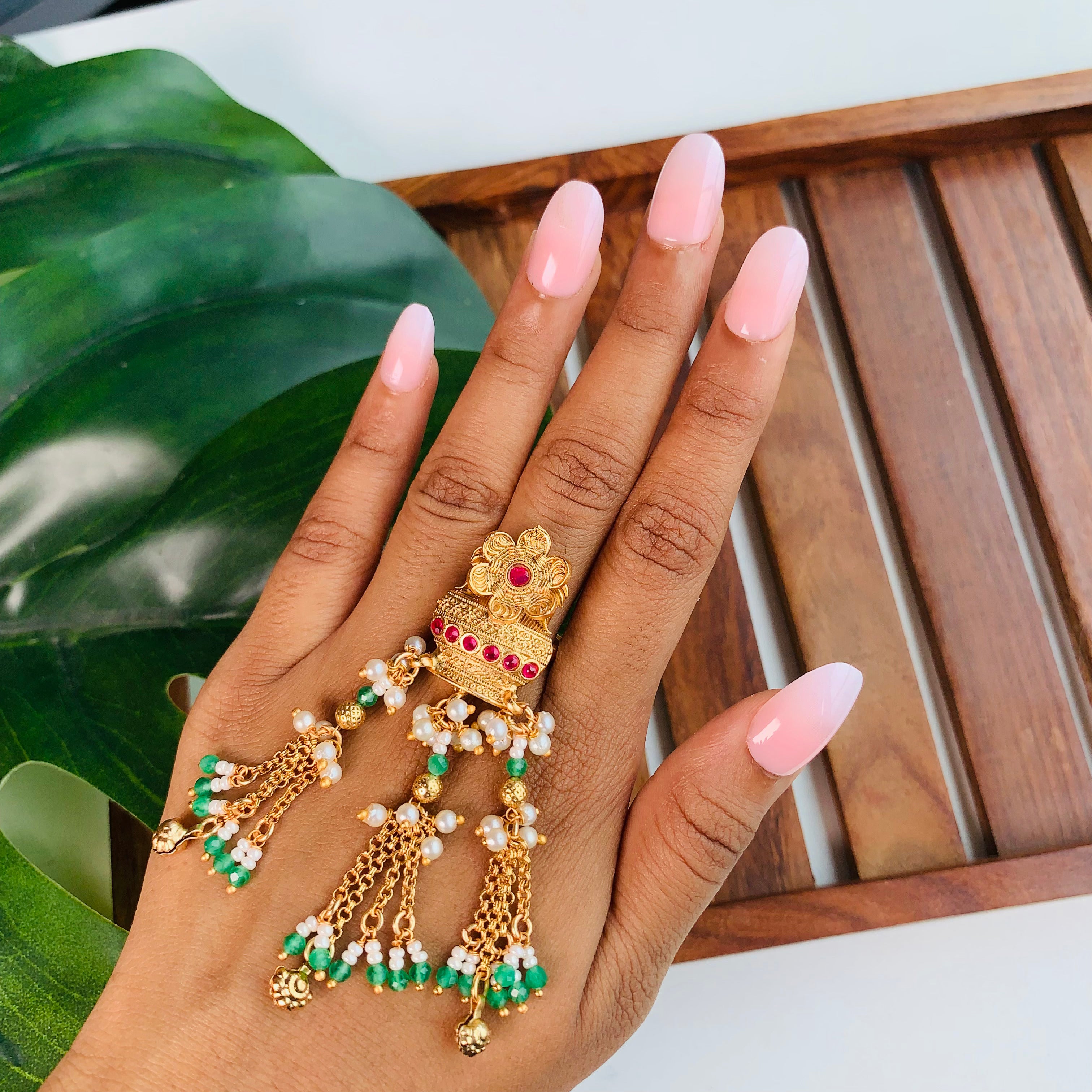 Temple jewelry finger ring for women with green beads, pearl tassels, and floral ruby design – perfect for Indian weddings and festive wear.