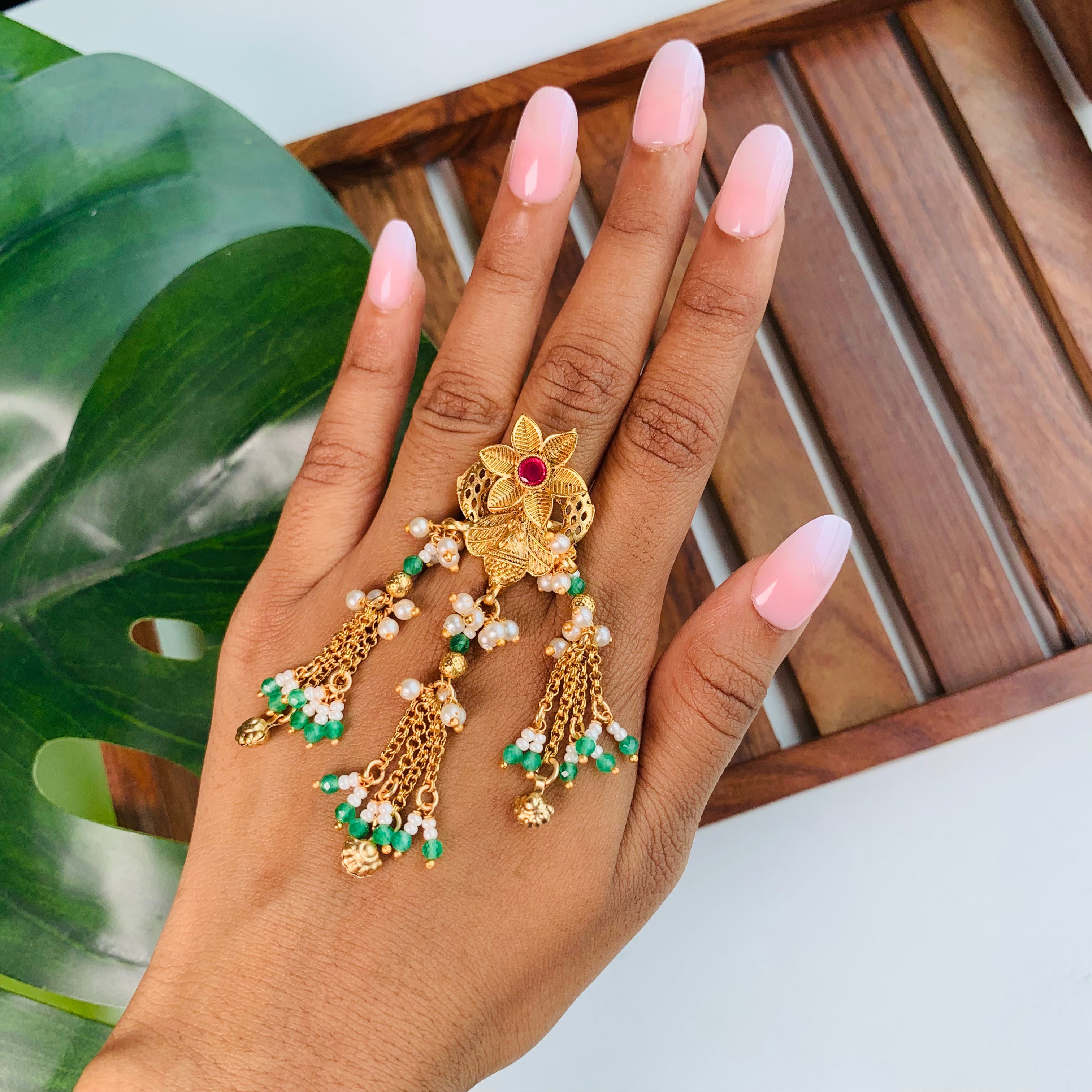 Statement finger ring for festive occasions with floral top, pearl and emerald tassels – ethnic jewelry for haldi, mehendi, and traditional outfits.