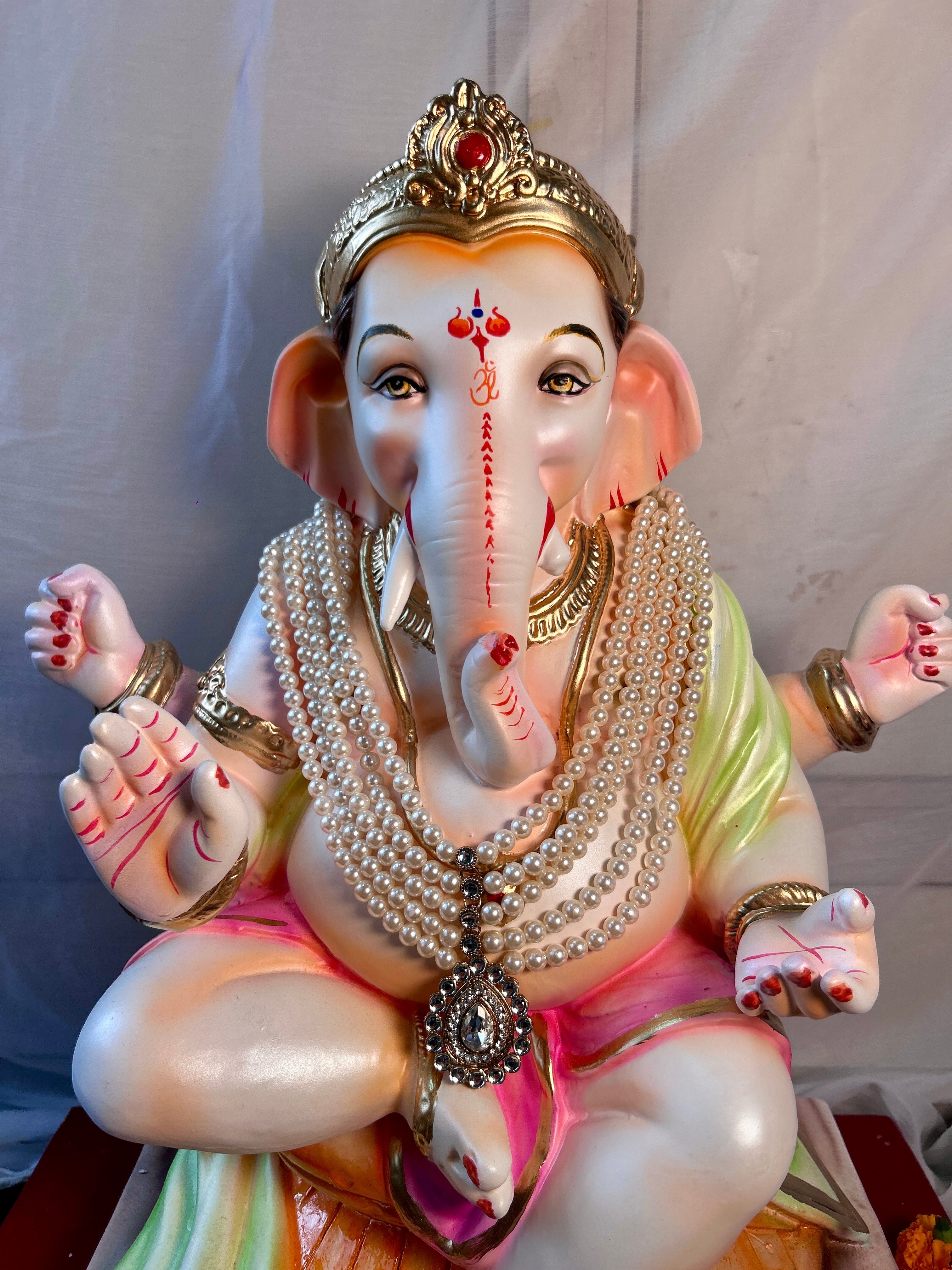 White and golden bead mala for Ganpati murti decoration and spiritual ambience.