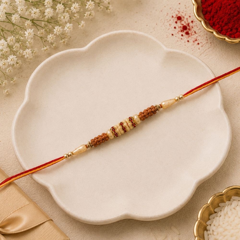 DELICATE PEARL BEADED MAROON RAKHI WITH ROLI CHAWAL & RAKSHABANDHAN CARD
