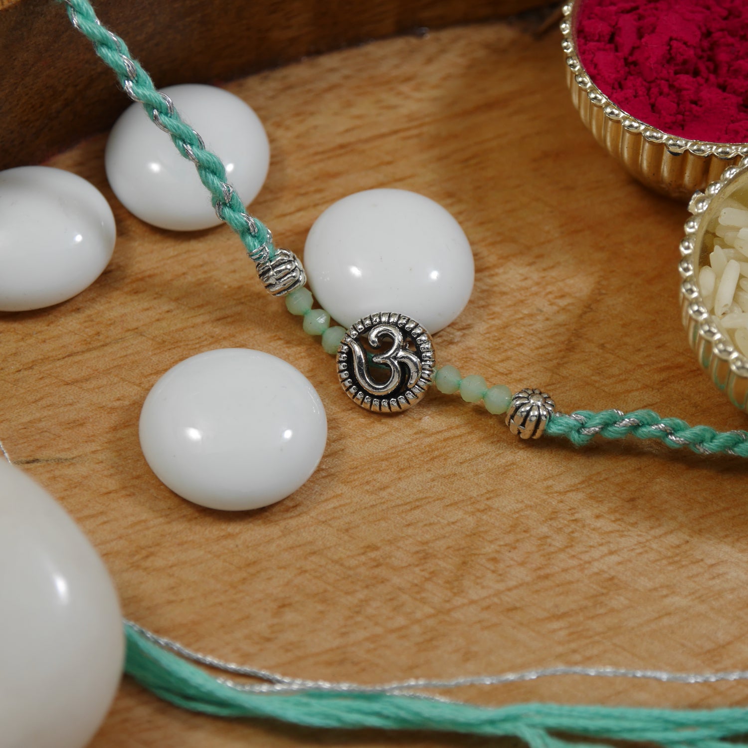 Elegant Om Rakhi with Mint Green Beads
