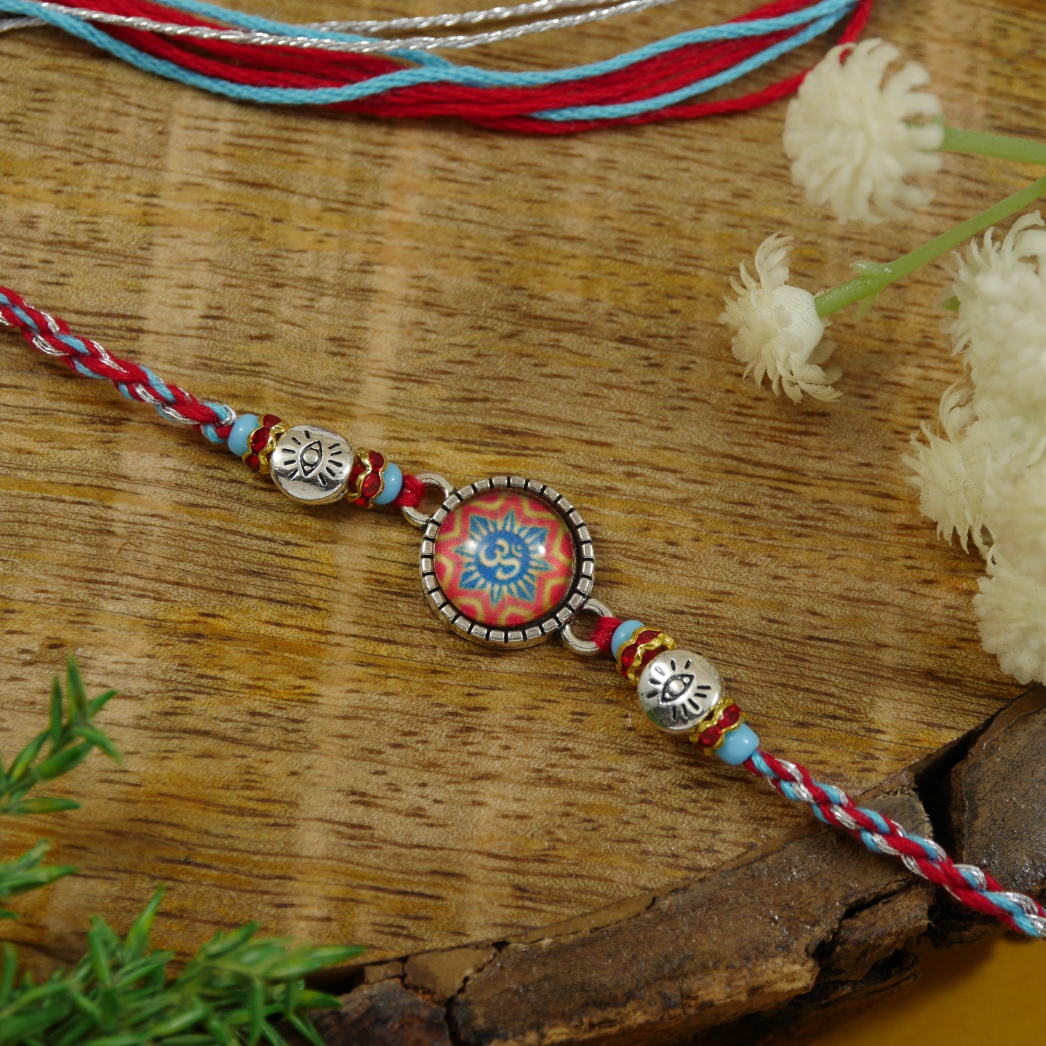 Enamel silver om rakhi for bhai with multicolour thread